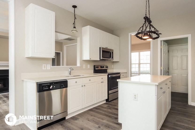 a white kitchen with stainless steel appliances and white cabinets