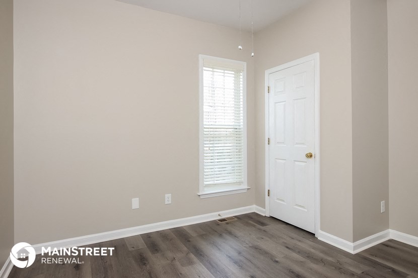 the interior of a room with a white door and wood floors