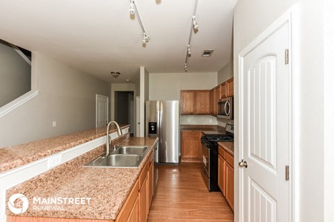 a large kitchen with granite counter tops and wooden cabinets