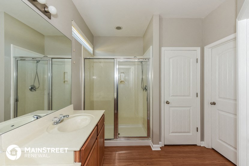a bathroom with a sink and a shower and a mirror