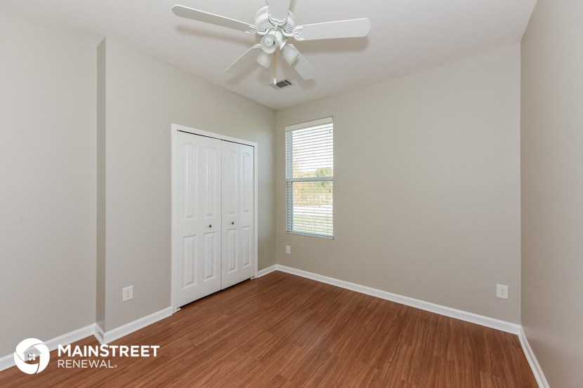 an empty room with a ceiling fan and a closet