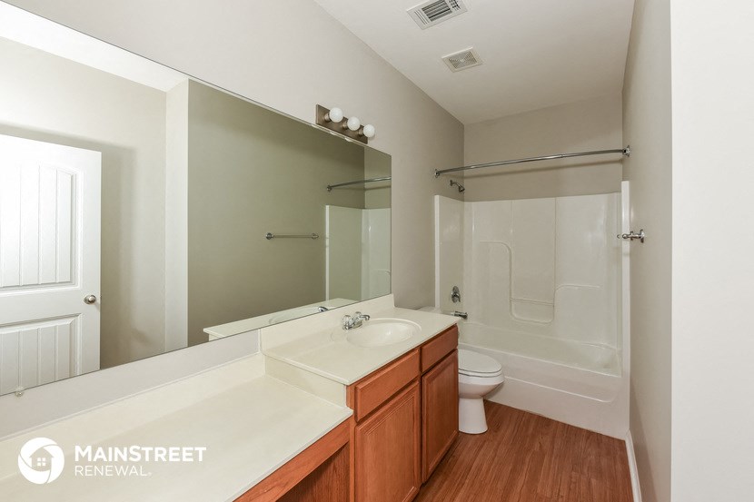 a bathroom with a large mirror and a sink and a toilet