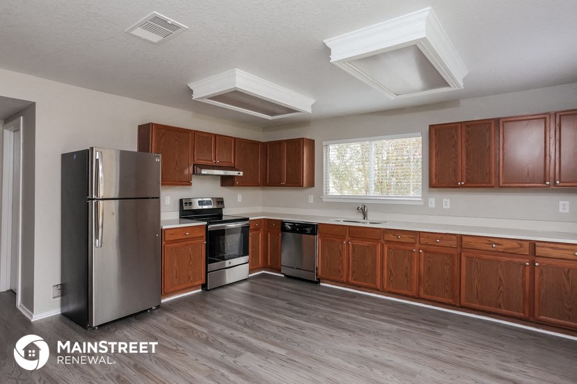 a kitchen with wooden cabinets and a stainless steel refrigerator