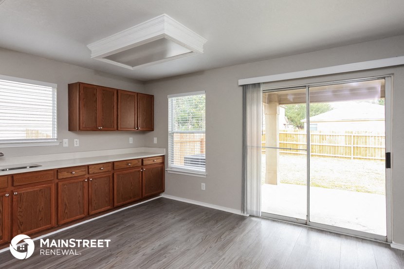 a kitchen with wooden cabinets and a sliding glass door