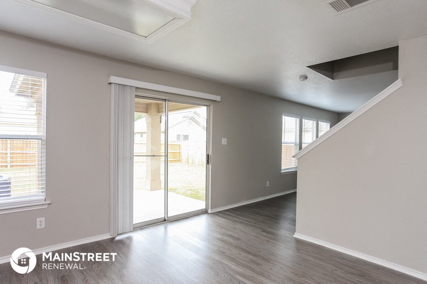 the living room of a new home with a door to the backyard