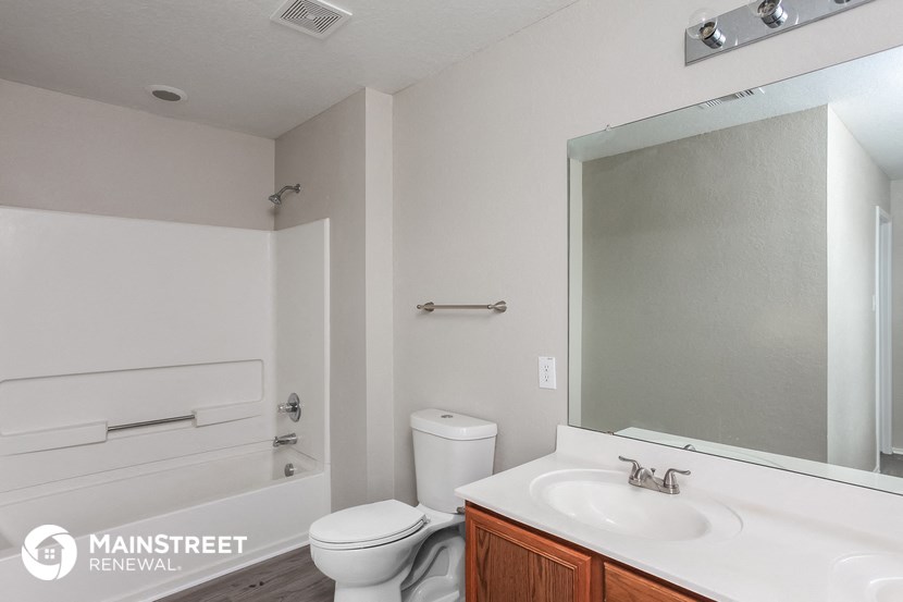 a bathroom with a sink toilet and a mirror