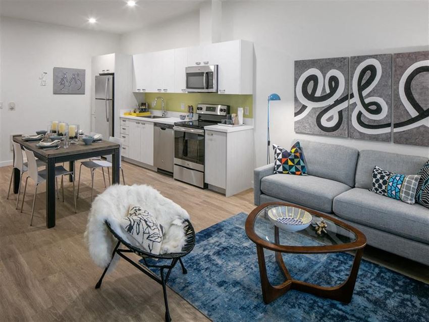 a living room and kitchen with a couch and a table