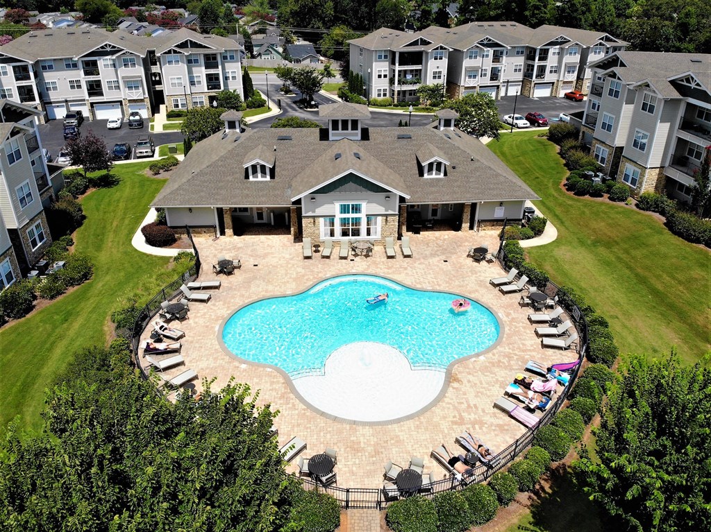 an aerial view of a large swimming pool in front of an apartment building