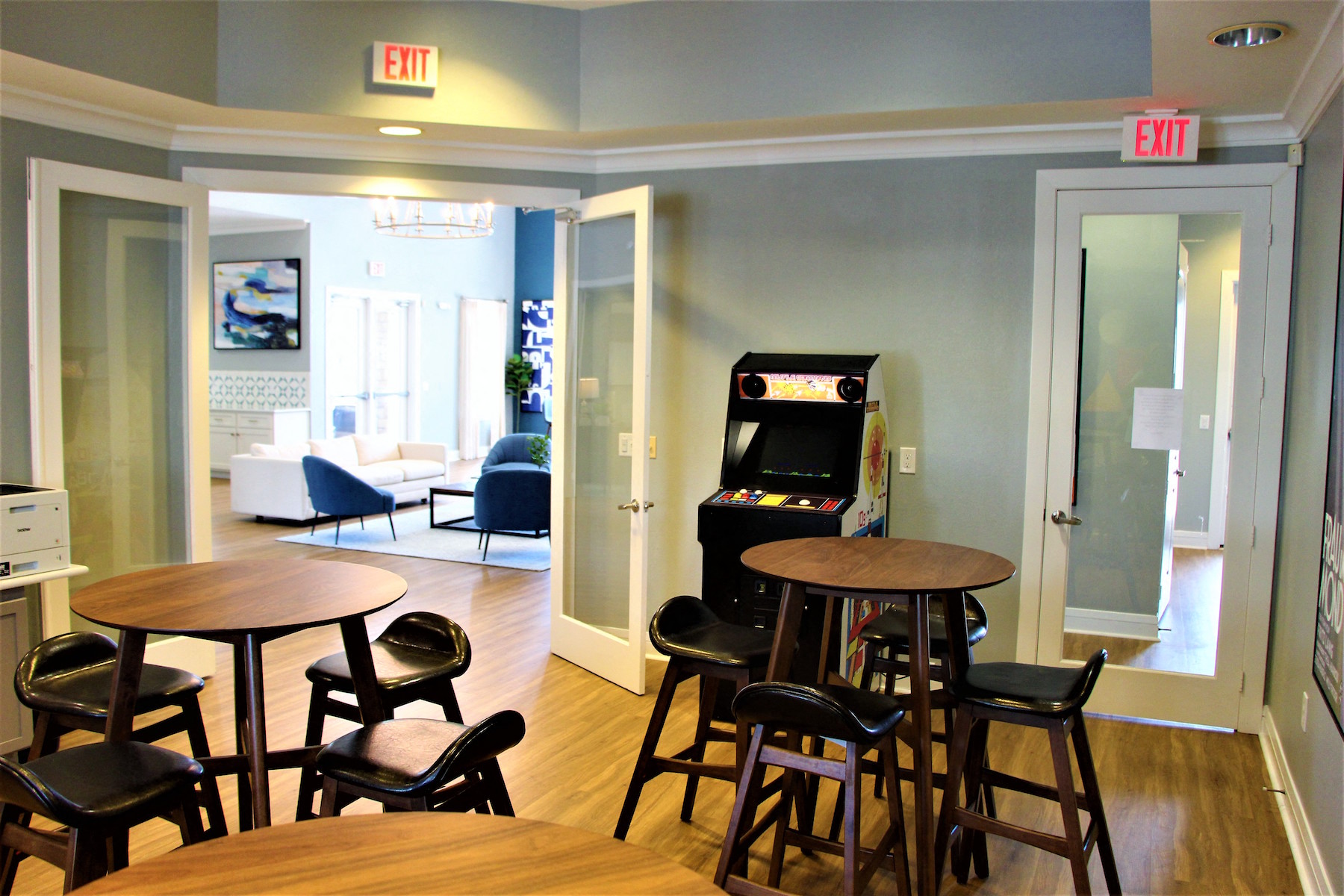a dining room with tables and chairs and an exit sign on the wall