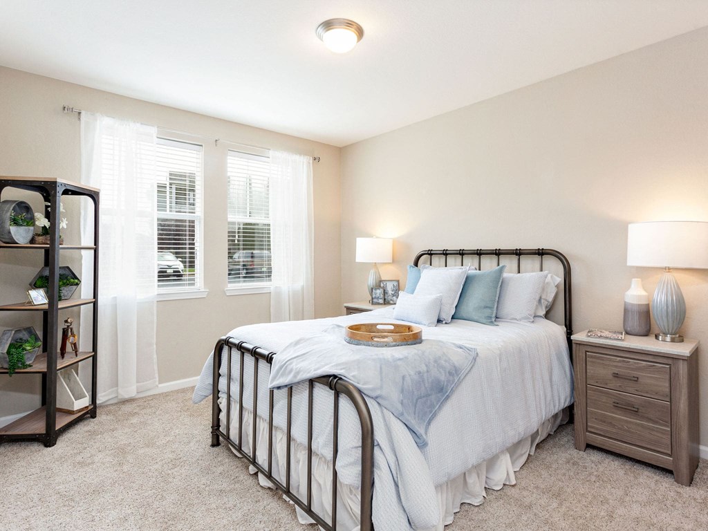 a bedroom with a bed and two windows