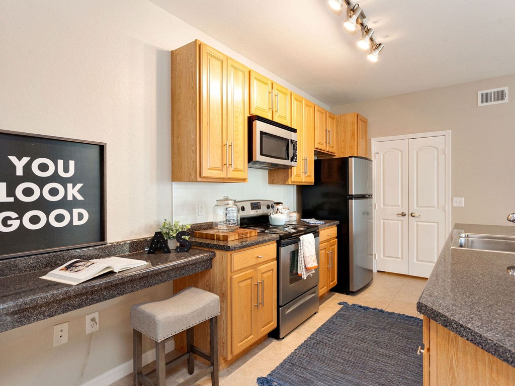 a kitchen with a granite counter top and a black refrigerator
