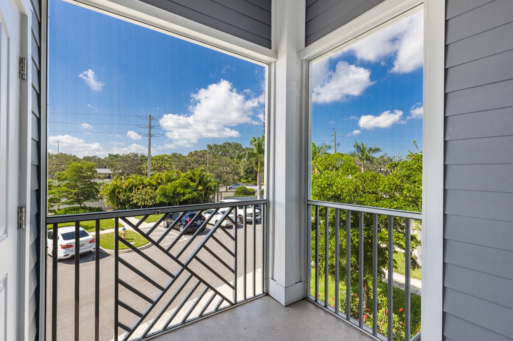 a balcony with a view of a parking lot and a blue sky