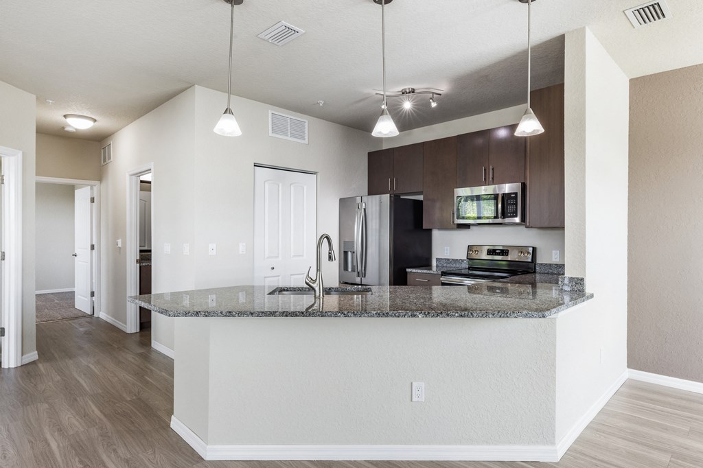 a kitchen with a granite counter top and a stainless steel refrigerator
