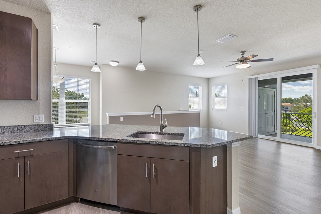 an open kitchen and living room with a sink and a ceiling fan