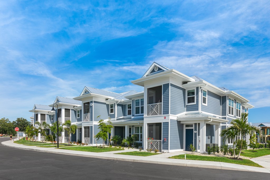 a row of blue and white houses on the side of a street