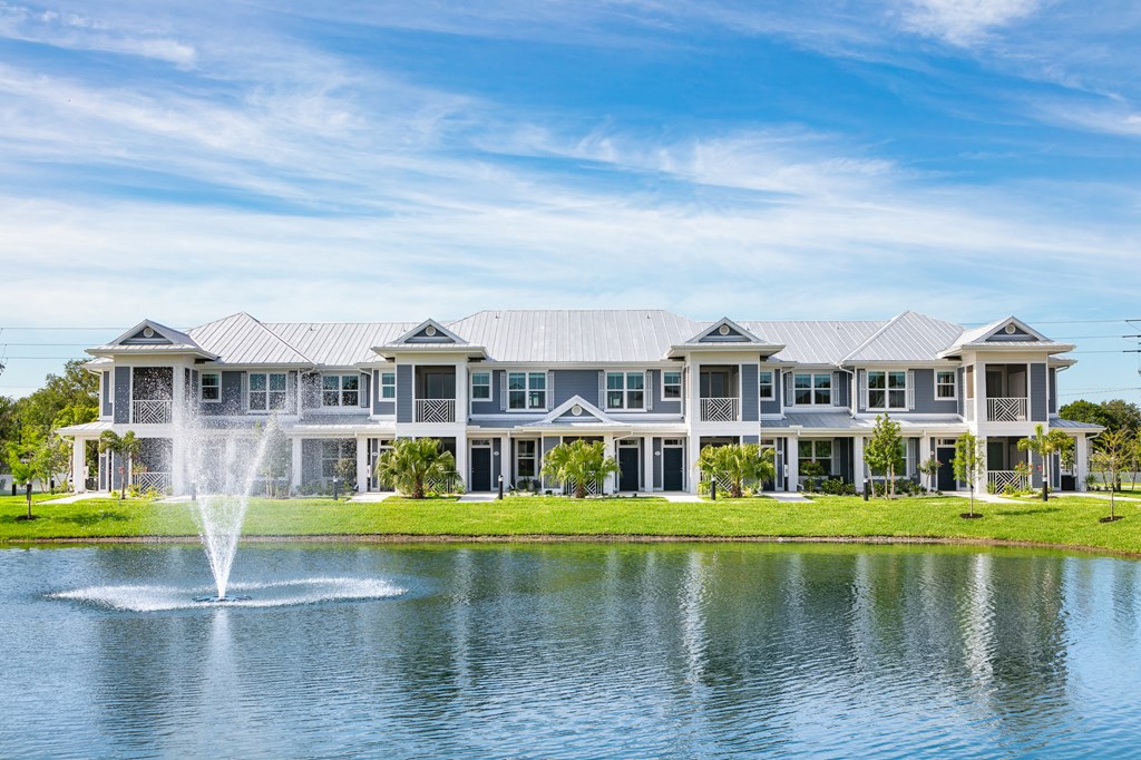 a fountain is in the water in front of a large building
