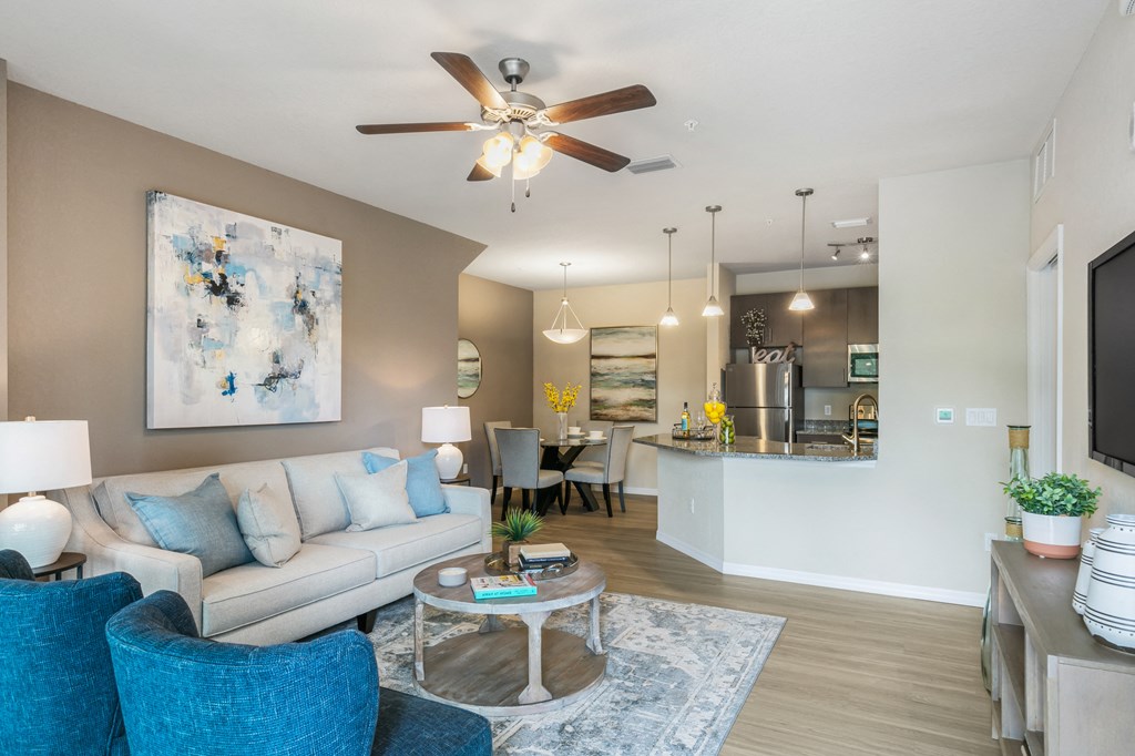 an open living room and kitchen with a ceiling fan