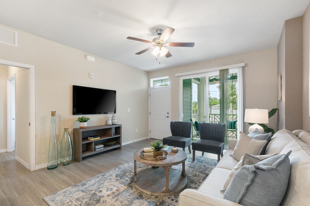 a living room with a couch and a coffee table and a ceiling fan