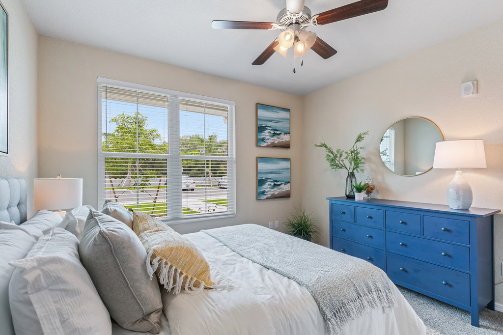 a bedroom with a large bed and a ceiling fan