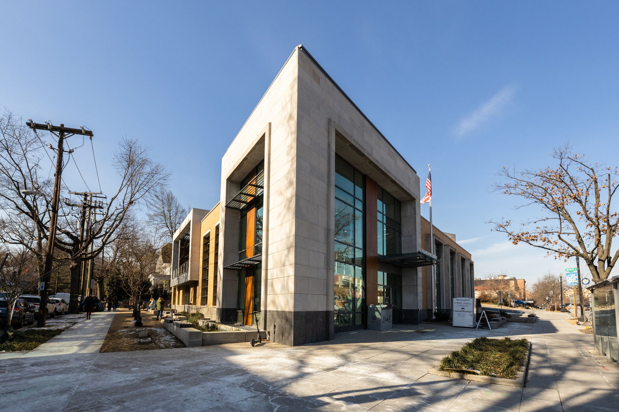 a large building with large glass windows and a street in front of it