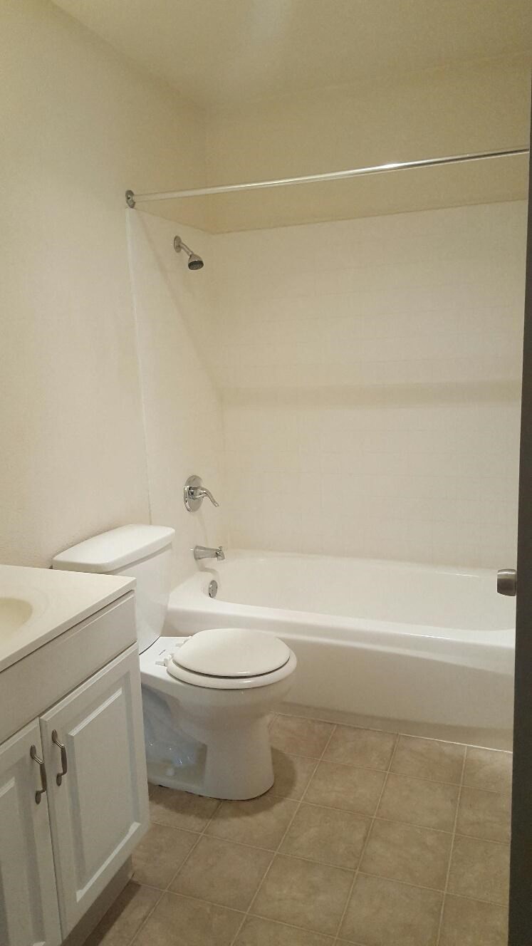 a bathroom with a toilet and a tub and a sink