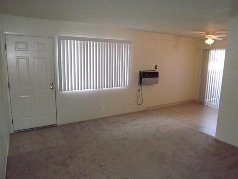 an empty living room with a window and a door