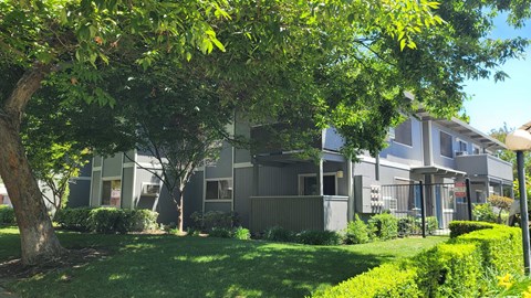 an apartment building with green grass and trees