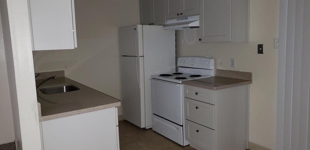 a kitchen with a stove refrigerator and sink