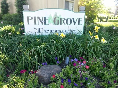 a sign for pine grove terrace in a garden