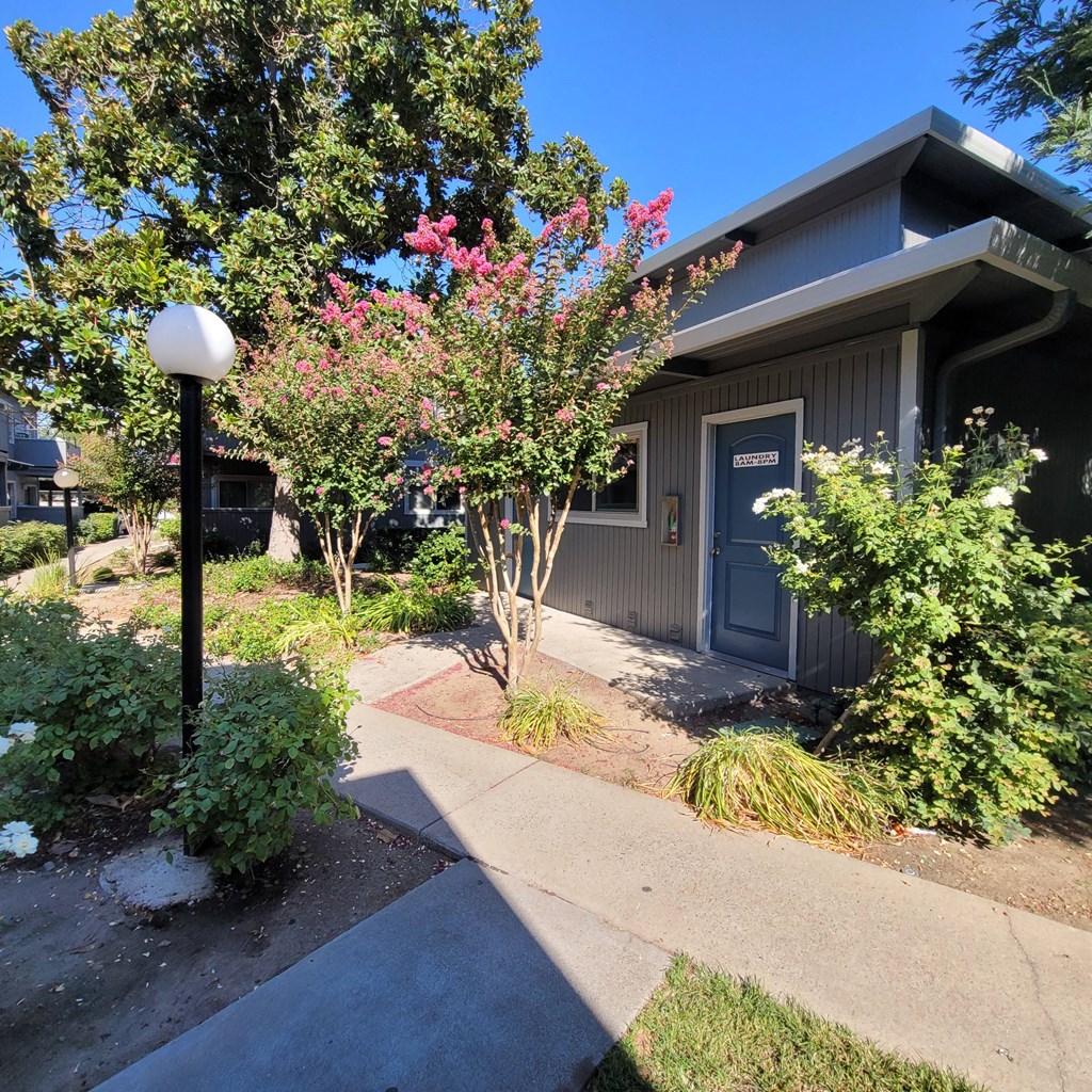 the front of a house with a sidewalk and a blue door