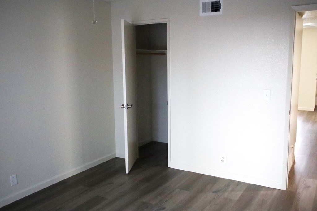 A room with a white door and a wooden floor.