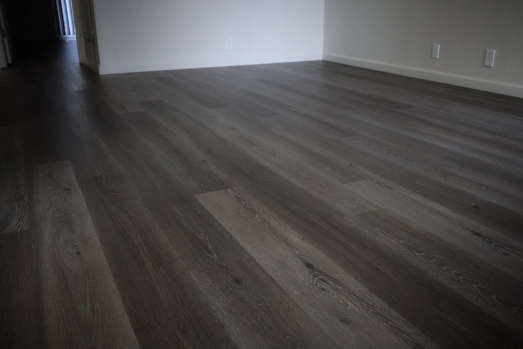 A room with a wooden floor and a white wall.