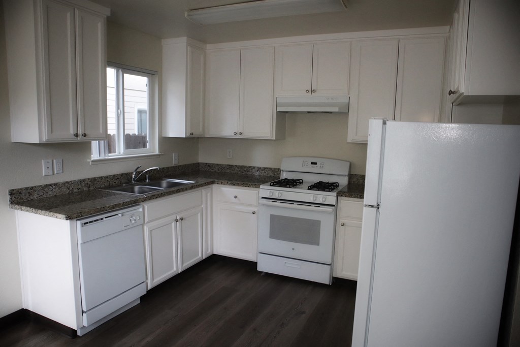 A kitchen with white appliances and cabinets.