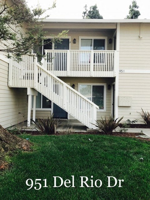 A two-story house with a balcony and stairs leading to the second floor.