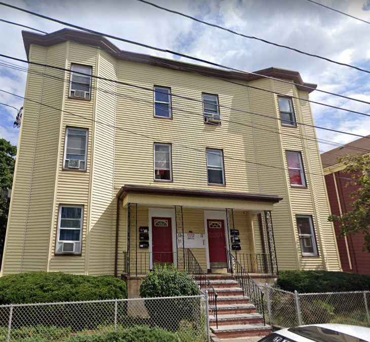 a yellow house with steps and a red door