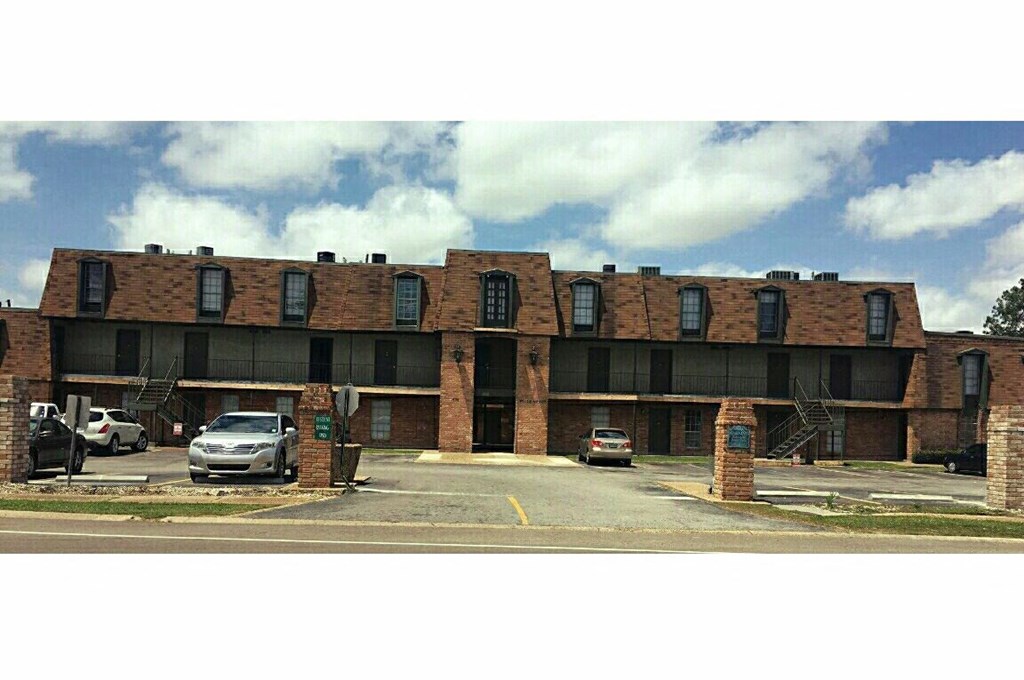 a large brick building with cars parked in front of it