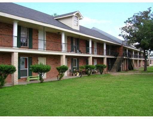 an apartment building with a green yard in front of it