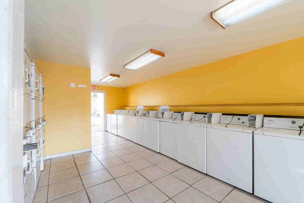 a laundry room with many washers and dryers in it