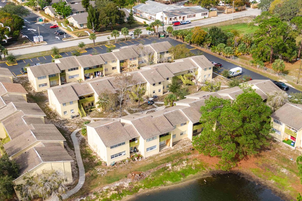 an aerial view of a group of houses next to a body of water