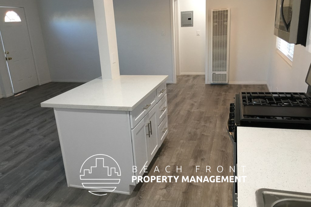 a renovated kitchen with white cabinets and a white counter top