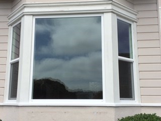 A white window with a view of the sky and clouds.