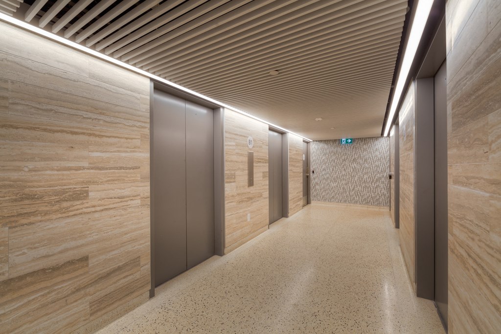 a hallway with elevators and wooden walls and flooring