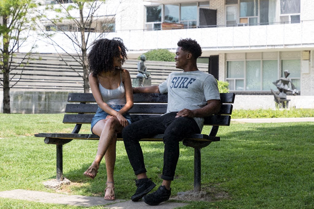 a man and a woman sitting on a park bench