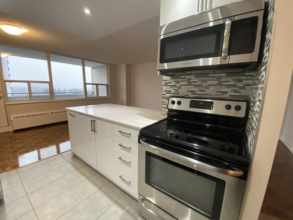 an empty kitchen with a stove and a microwave