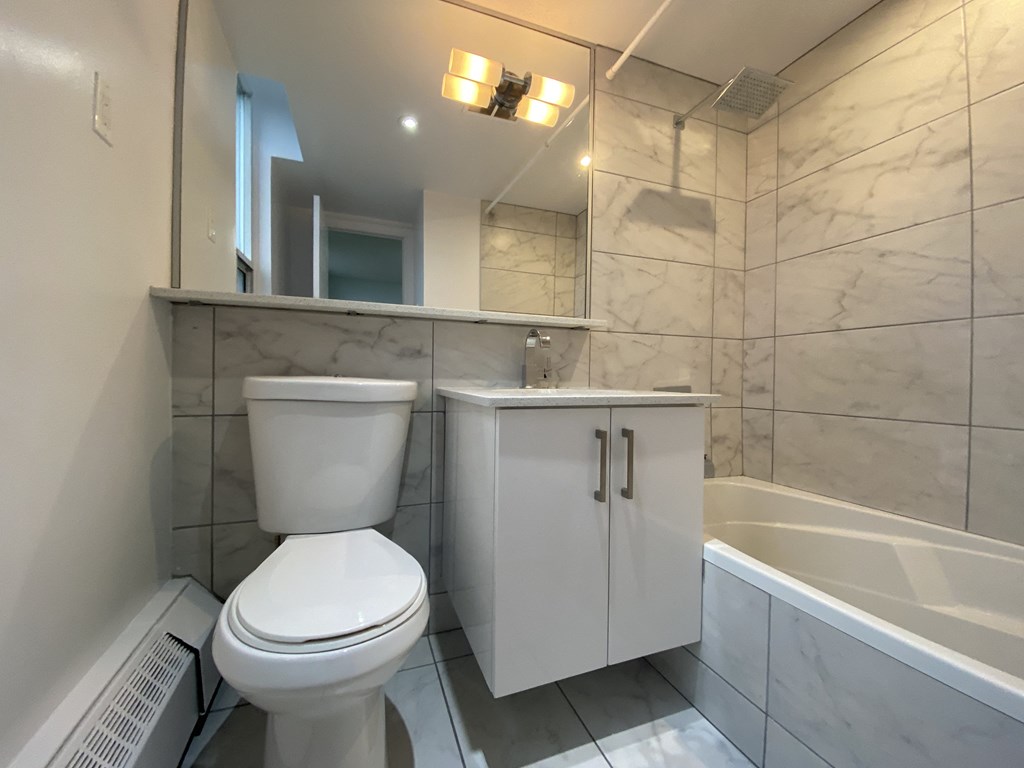 a bathroom with a toilet and a sink and a bath tub