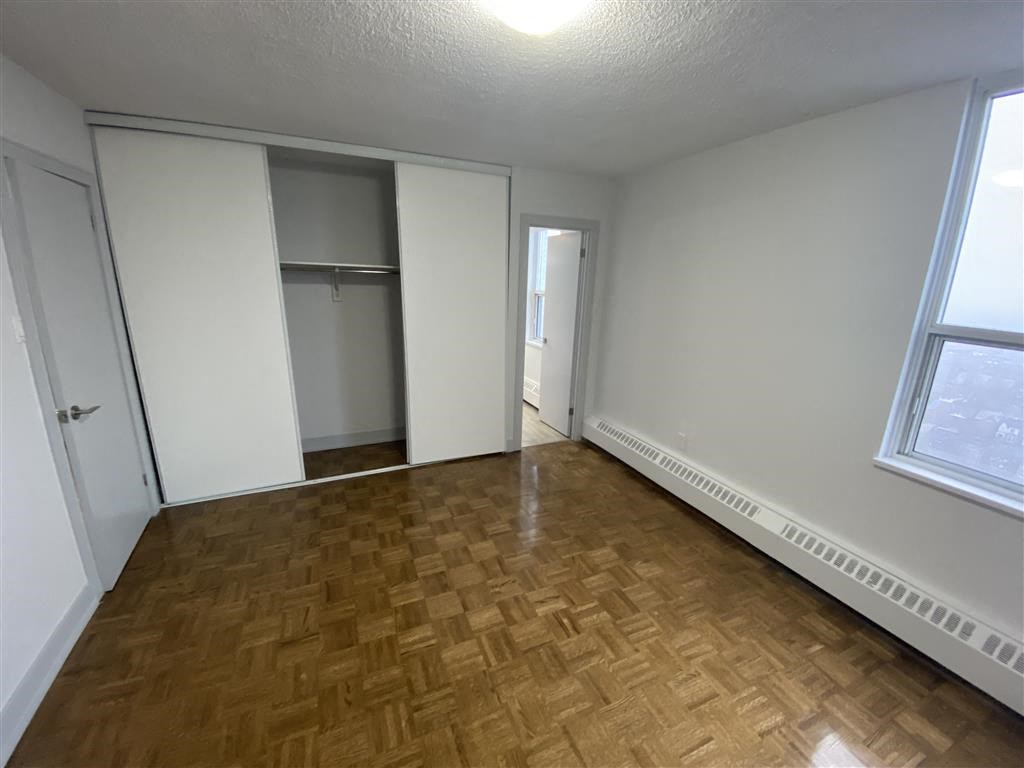 an empty living room with a wood floor and a closet