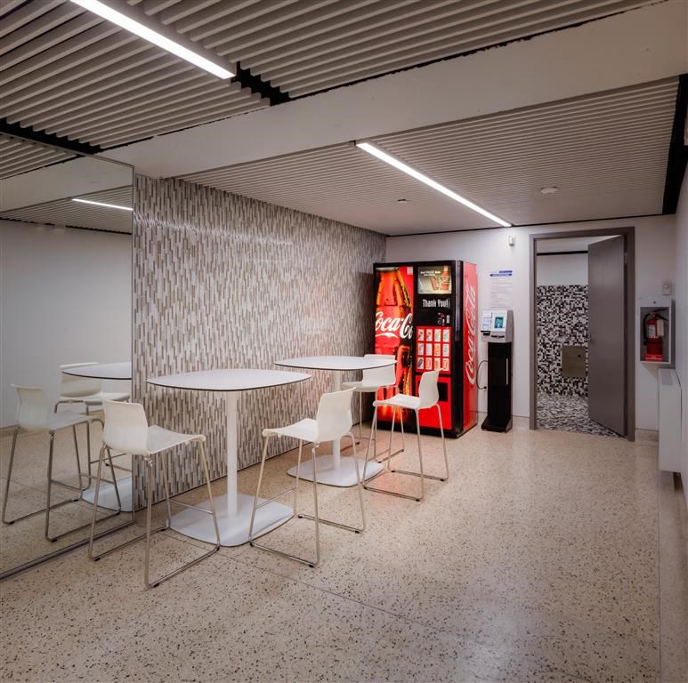 a vending machine in a room with tables and chairs