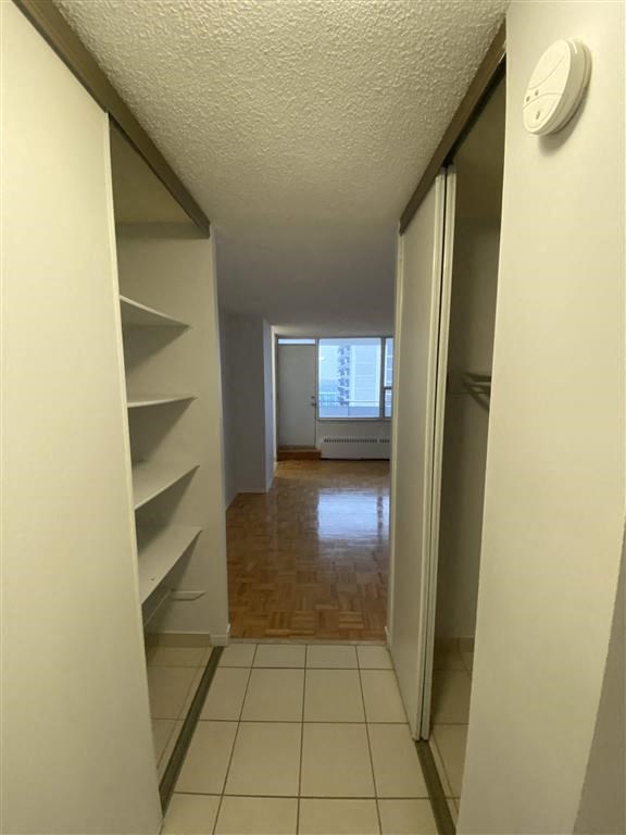 a hallway with a clock on the wall and a closet