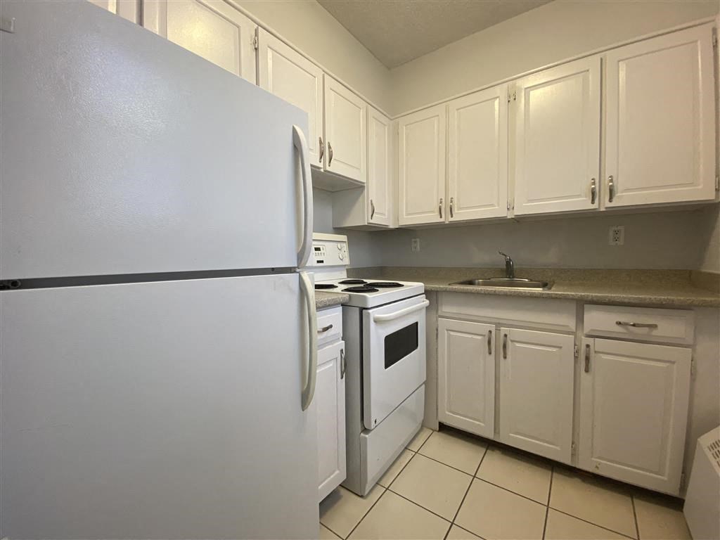 a kitchen with white appliances and white cabinets