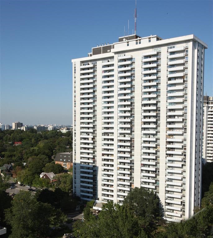a tall building with many windows and a city in the background